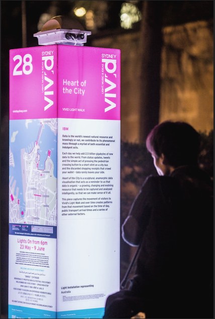A wireless access point mounted on top of a pink Vivid Sydney wayfinding totem at night