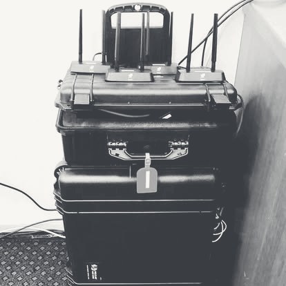 A stacked pelican-case bonded WAN rig with antennas, graphite monochrome
